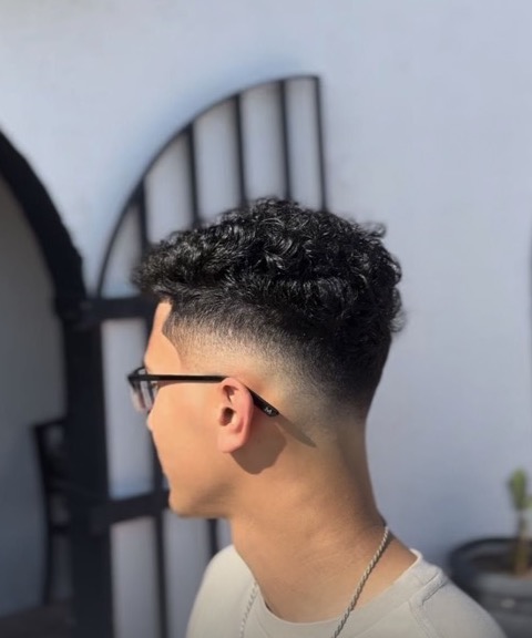 Curly top with a mid fade and clean taper